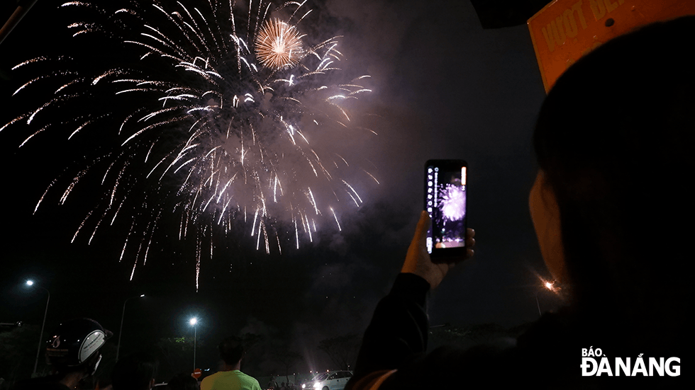 People take pictures of fireworks to keep memories about Lunar New Year's Eve. Photo: THU DUYEN 