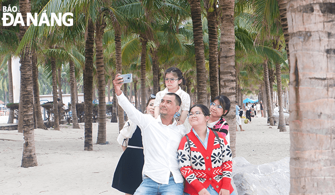 A family is posing for a group photo at the My Khe beach.