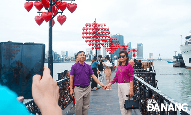 Foreign tourists take souvenir photos at Love Bridge