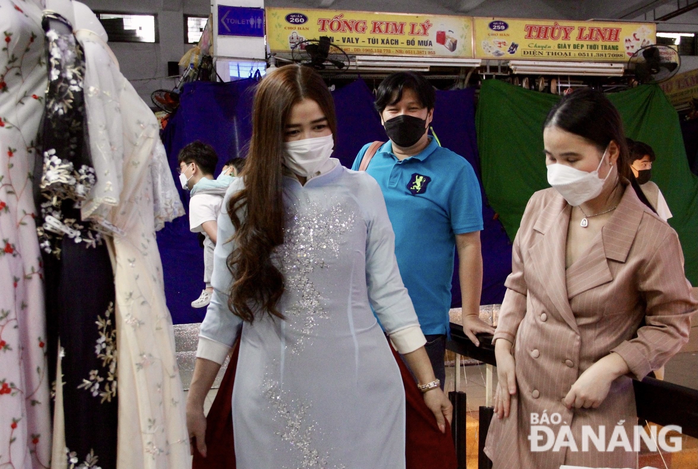 Ms. Samponk The Hai happily tried on 'Ao Dai' at the Ut Thuong stall at the Han Market. Photo: X.HAU