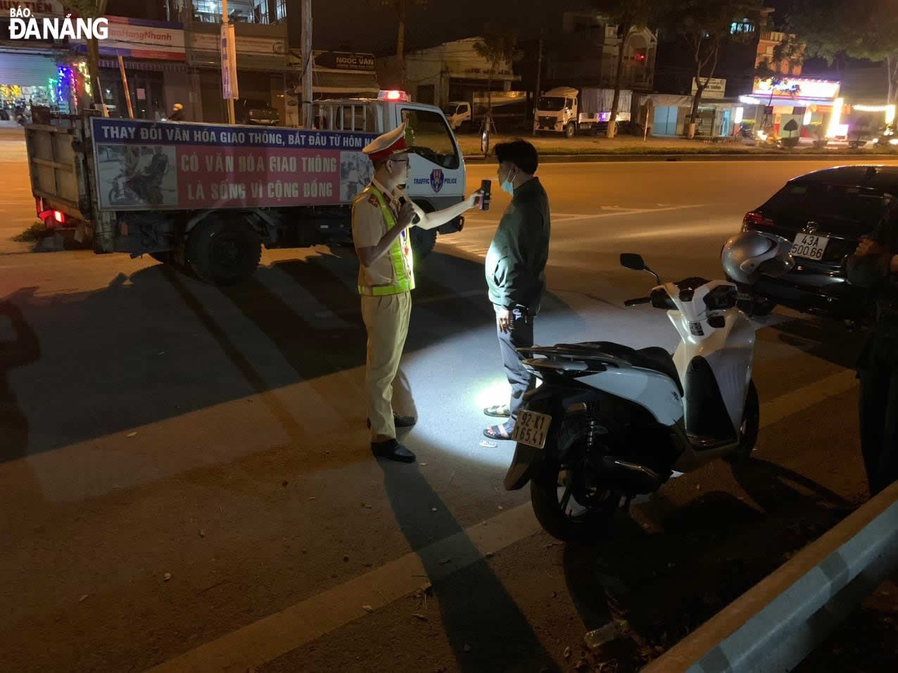 A traffic police officer measures the breath alcohol concentration of a driver 