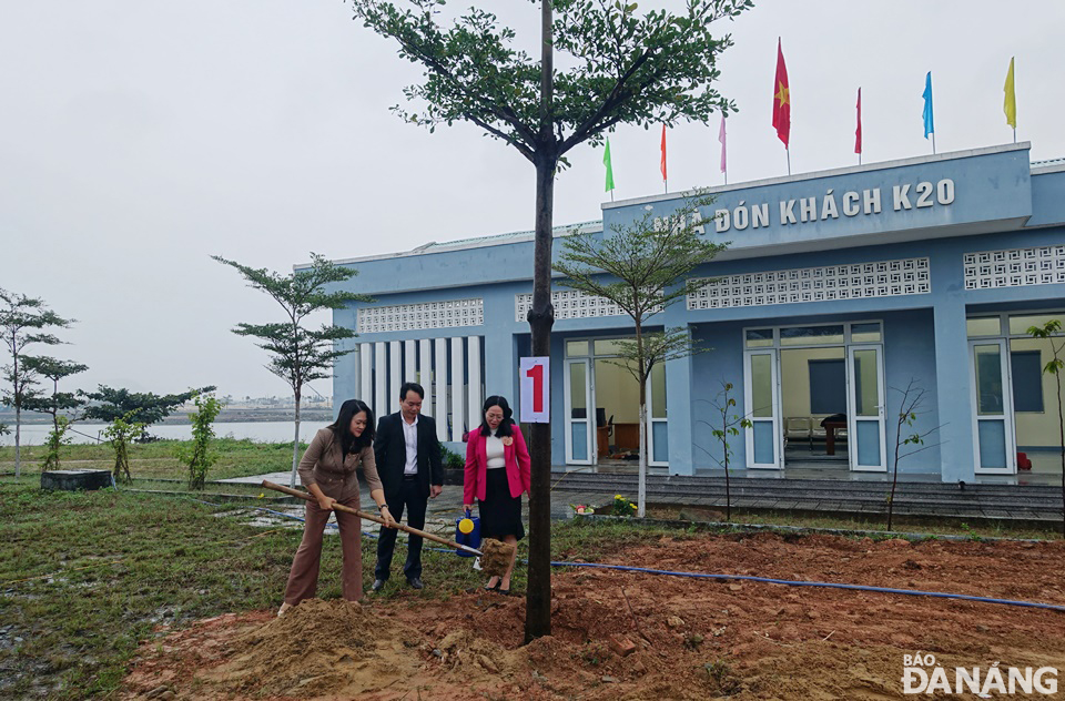 Bí thư Quận ủy Ngũ Hành Sơn Cao Thị Huyền Trân (trái) trồng cây bóng mát phía trước nhà đón khách của bến thủy nội địa K20. Ảnh: HOÀNG HIỆP