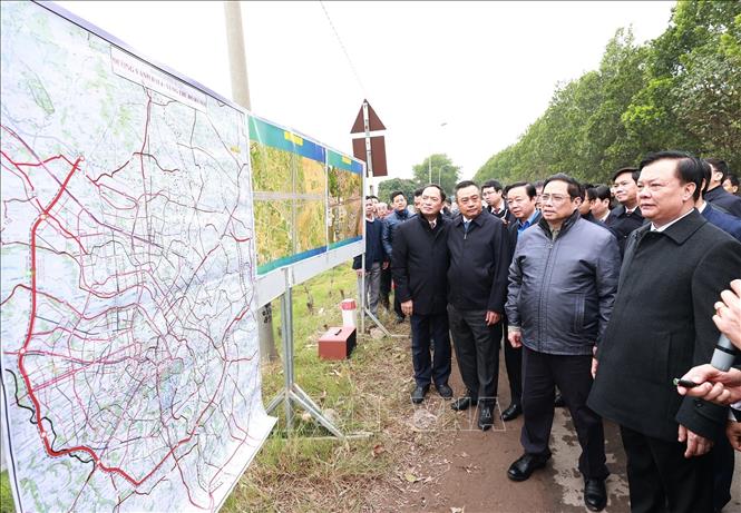 Thủ tướng Phạm Minh Chính xem bản đồ tuyến đường vành đai 4 vùng Thủ đô Hà Nội tại điểm xã Song Phương, huyện Hoài Đức. Ảnh: Dương Giang/TTXVN