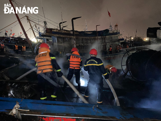 Tàu cá bốc cháy được lực lượng chức năng phối hợp chữa cháy trong tối 27-1. Ảnh: N.Q
