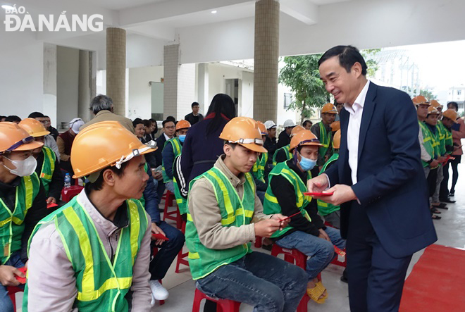 Chủ tịch UBND thành phố Lê Trung Chinh lì xì cho các công nhân thi công công trình Nâng cấp, cải tạo Trường THPT Phan Châu Trinh (cơ sở 154 Lê Lợi). Ảnh: HOÀNG HIỆP