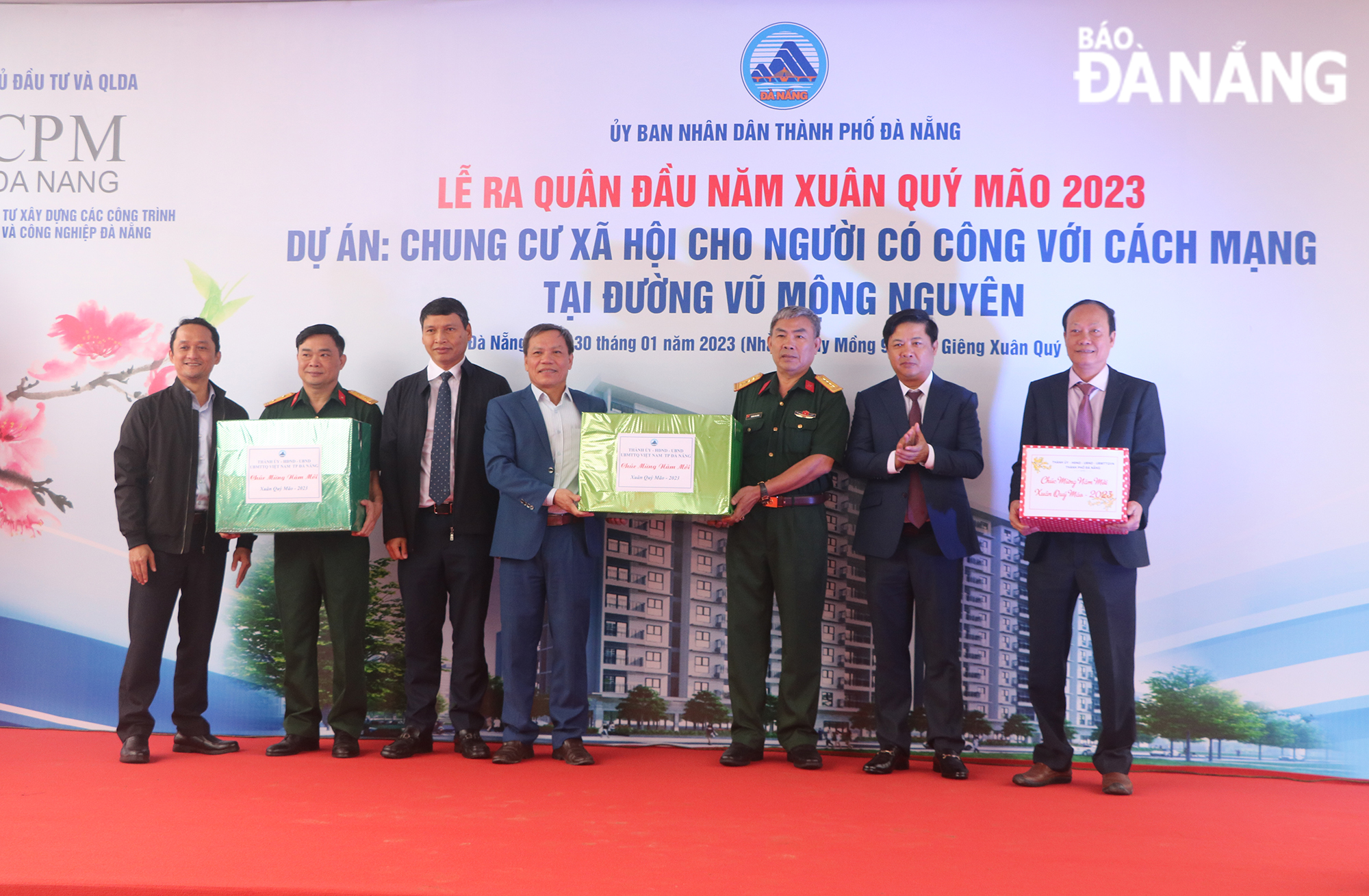 Municipal Party Committee Deputy Secretary cum People’s Council Luong Nguyen Minh Triet (2nd, right) and Vice Chairman of the local People's Committee Ho Ky Minh (3rd, left) present gifts to investors and contractors of the social housing project for people with meritorious services to the revolution on Vu Mong Nguyen Street . Photo: VAN HOANG