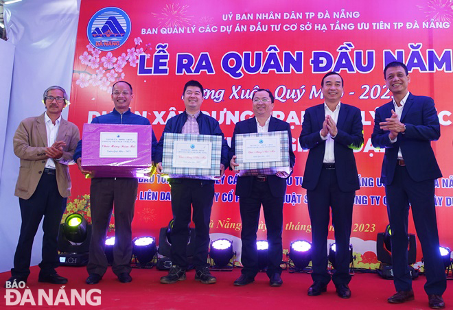 Municipal People’s Committee Chairman Le Trung Chinh (2nd, right) gives gifts to construction units at the 3rd stage of the existing Hoa Xuan wastewater treatment plant .