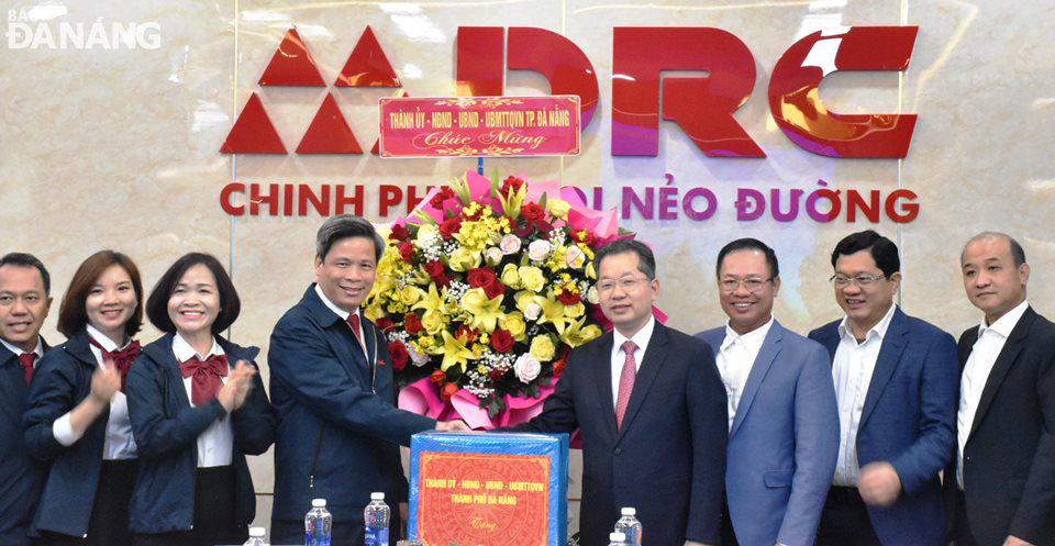 Secretary of the municipal Party Committee Nguyen Van Quang (4th, right), Vice Chairman of the People's Council Tran Phuoc Son (3rd, right), Vice Chairman of the People's Committee Le Quang Nam (first right) present a gift to the Da Nang Rubber JSC. Photo: Q.TRANG