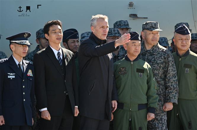 Tổng thư ký NATO Jens Stoltenberg (giữa) trong chuyến thăm Căn cứ không quân Iruma, Nhật Bản, ngày 31-1. Ảnh: AFP/ TTXVN