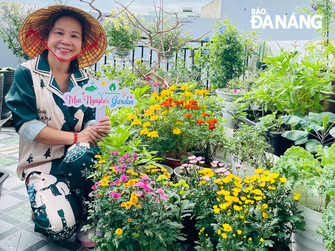 Nguyen Thi Mai next to her own garden of trees and flowers. Photo: T.V