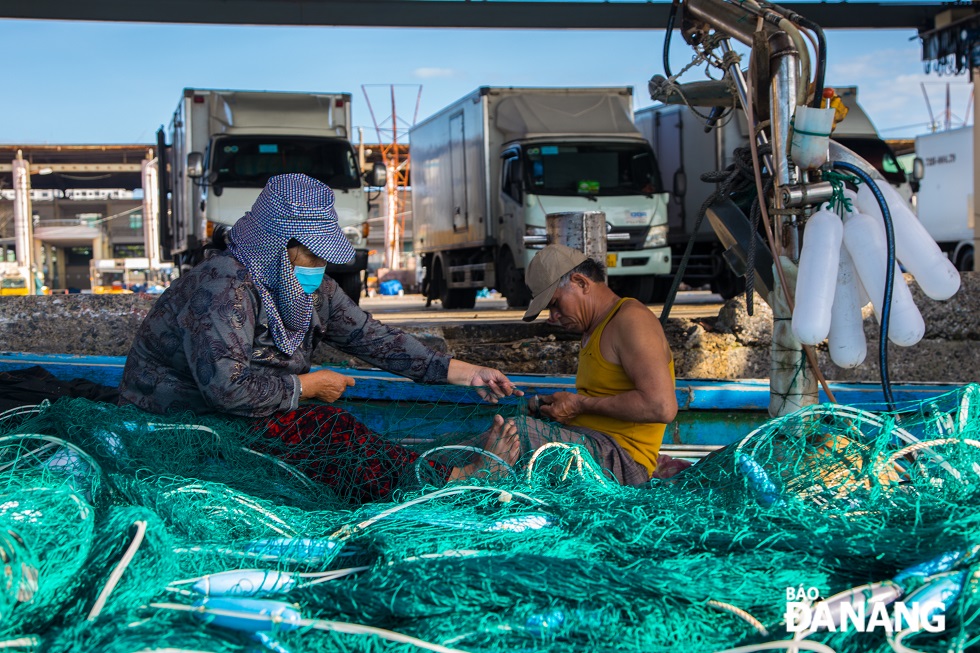 A fisherman couple is seen checking fishing net in preparation for their first fishing trip at the beginning of the year