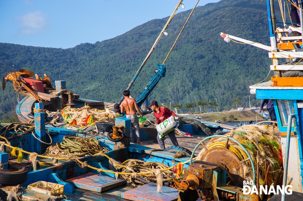 The fishermen are busy mending nets, and transporting ice to fill up the compartment, waiting for the beautiful time to leave the wharf.