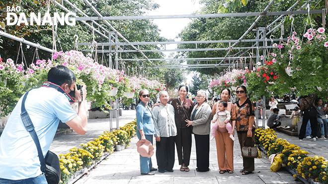 Mrs. Dang Thi Ngoc Mai, a visitor from Ho Chi Minh City, (4th, right) with her family came to the Linh Ung Pagoda to pray for peace during her trip to Da Nang.