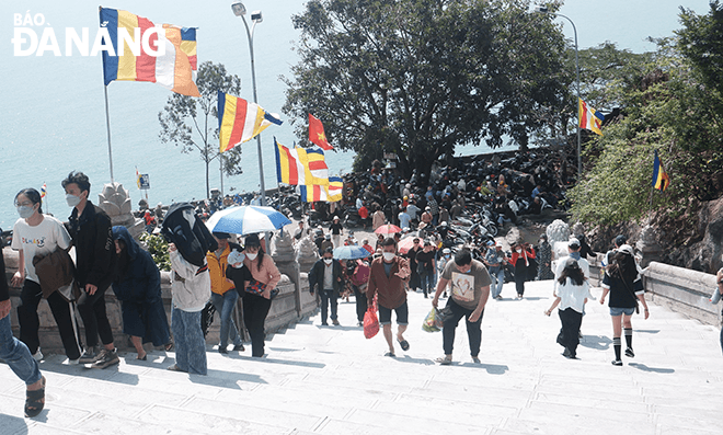 Busy line of people continuously offered flowers and prayed for peace at the Linh Ung Pagoda despite the hot weather