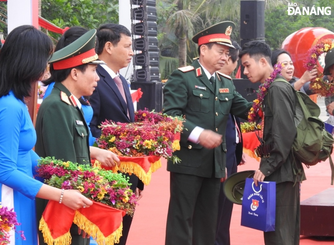 Phó Chủ tịch Thường trực UBND thành phố Hồ Kỳ Minh và lãnh đạo Quân khu 5 tặng hoa chúc mừng tân binh quận Cẩm Lệ. Ảnh: L.H