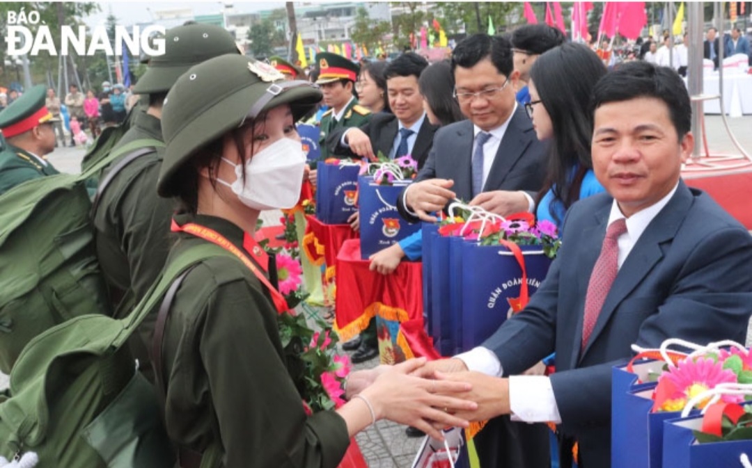 Trưởng Ban Nội chính Thành ủy Võ Công Chánh (phải) tặng quà chúc mừng tân binh quận Liên Chiểu. Ảnh: NGỌC HÀ