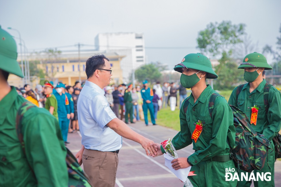 A leader of the local government shook hands to say goodbye to the new recruits when they got on coaches to their unit. Photo: CHANH LAM 