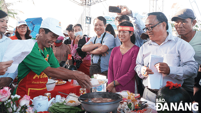 Thành viên đội thi phường Hòa Khê đưa món ăn để ban giám khảo chấm điểm.