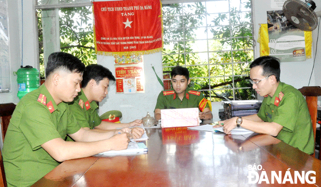 Thượng úy Ngô Ngọc Phú (bên phải), Đại úy Trần Quang Vinh (thứ 2, bên trái sang) và Thượng úy Trần Hữu Tuyết (ngoài cùng bên trái) thông báo tình hình tại địa bàn cơ sở cho trực ban. Ảnh: LÊ HÙNG