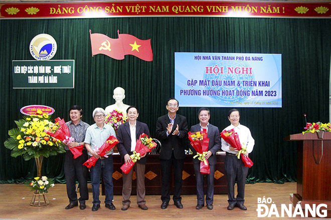 Phó Chủ tịch Liên hiệp các Hội văn học - nghệ thuật thành phố Nguyễn Nho Khiêm (thứ 3, phải qua) tặng hoa chúc mừng các tác giả đoạt giải thưởng văn học nghệ thuật thành phố lần thứ 4 (2015-2020). Ảnh: X.D