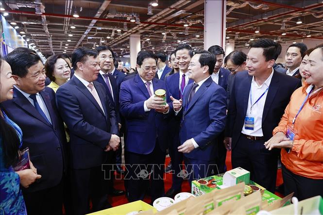 Thủ tướng Phạm Minh Chính xem trưng bày sản phẩm nông nghiệp, thủ công, mỹ nghệ của các tỉnh Đồng bằng sông Hồng. Ảnh: Dương Giang/TTXVN