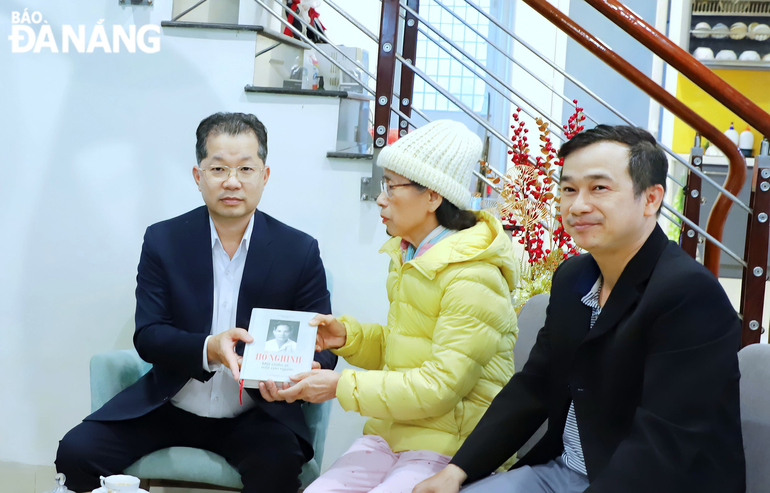 A relative of late secretary Ho Nghinh (centre) gave Mr. Quang the book entitled 