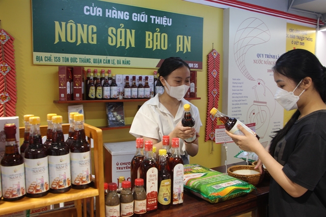 A sale woman offers fish sauce product of Nam Ô Village at a supermarket in downtown Đà Nẵng City . It's the first artisanal fish sauce that is available at supermarkets. Photo courtesy of Nhat Huy