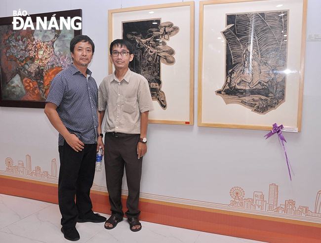 Họa sĩ Trương Nguyễn Nguyên Kha (bên phải) bên tác phẩm Trò chơi vẽ trò chơi trồng nụ trồng hoa. Ảnh: T.Y