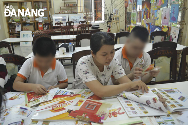 Ms Sinh (middle) helps autistic children study.