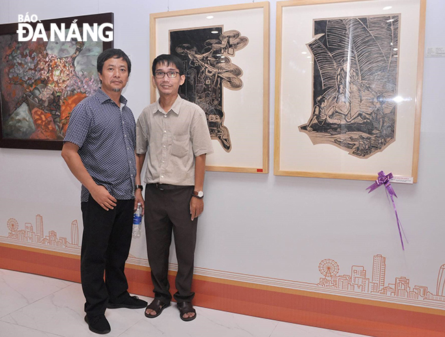 Painter Truong Nguyen Nguyen Kha (right) and his painting about the ''planting buds and flowers'' folk game. Photo: T.Y