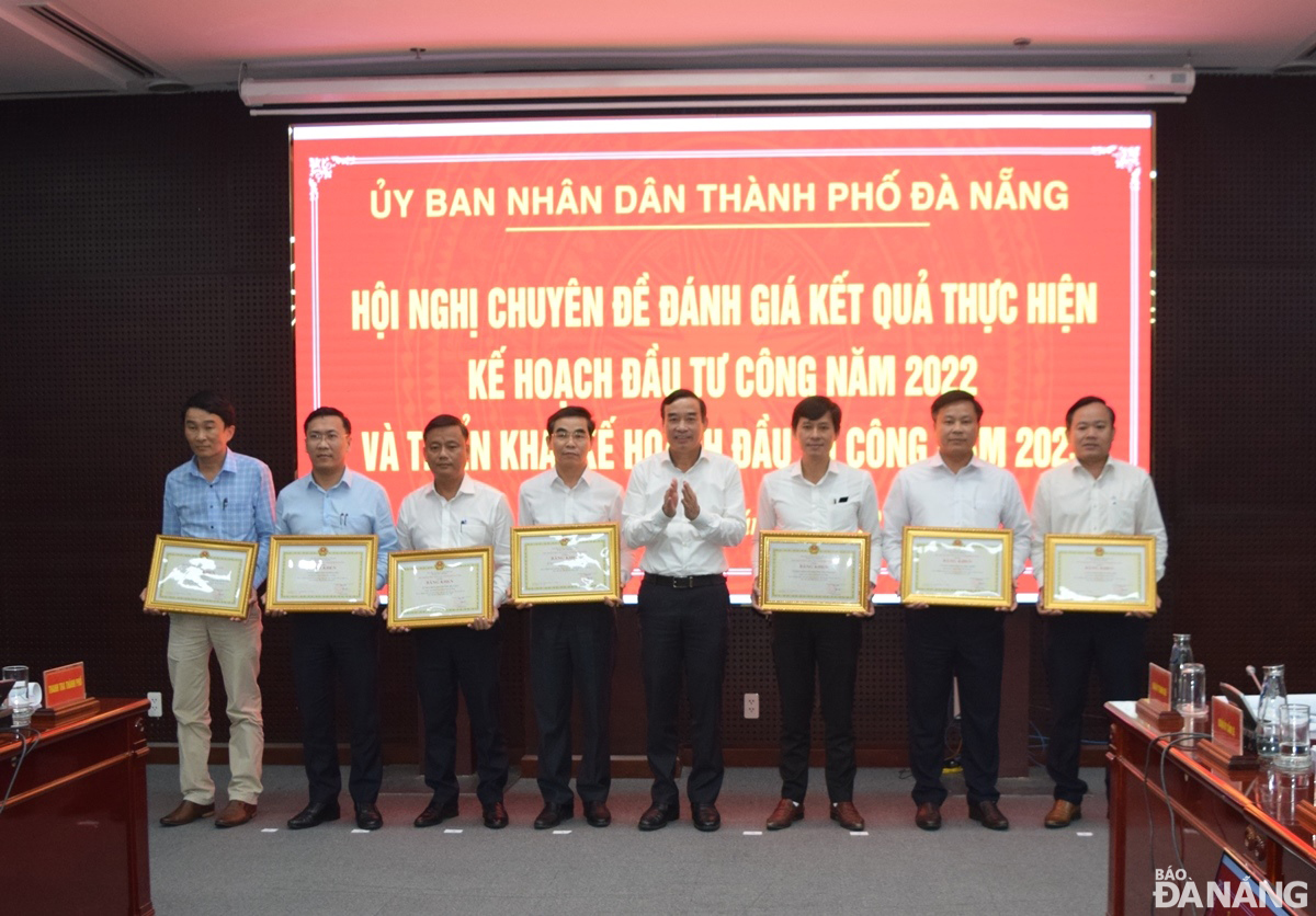 Chủ tịch UBND thành phố Lê Trung Chinh trao bằng khen cho 7 tập thể có thành tích xuất sắc trong công tác đền bù giải tỏa các dự án trên địa bàn thành phố trong năm 2022. Ảnh: HOÀNG HIỆP