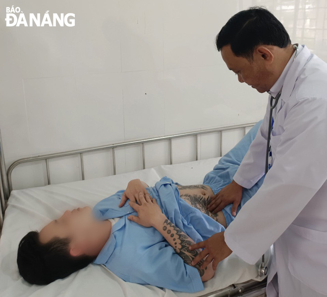 Dr. Luong Van Dung (right) giving medical treatment to a patient at the Bau Bang Drug Rehabilitation Centre 