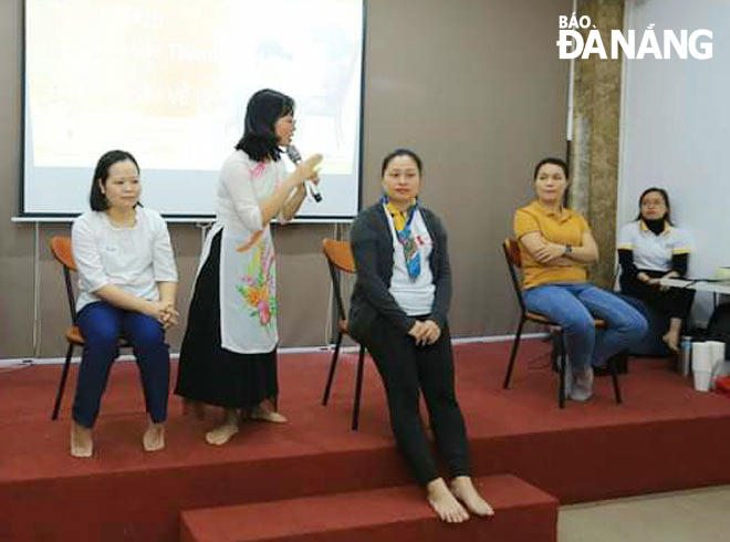 Chị Nguyễn Thị Trà (người cầm mic) đang chia sẻ các thông tin về tuổi dậy thì mà cha mẹ cần lưu ý. Ảnh: H.L