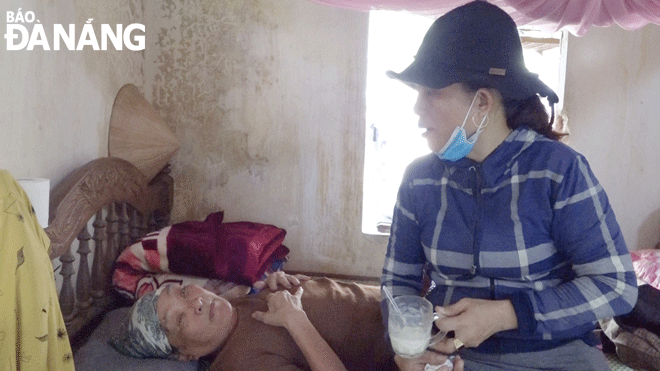 Ms. Phan Thi Minh Nguyet, the Chief of the Nhon Tho 2 Village Women's Union chapter in Hoa Phuoc Commune devotedly takes care of the sick elderly in the village. Photo: C.CHIEN