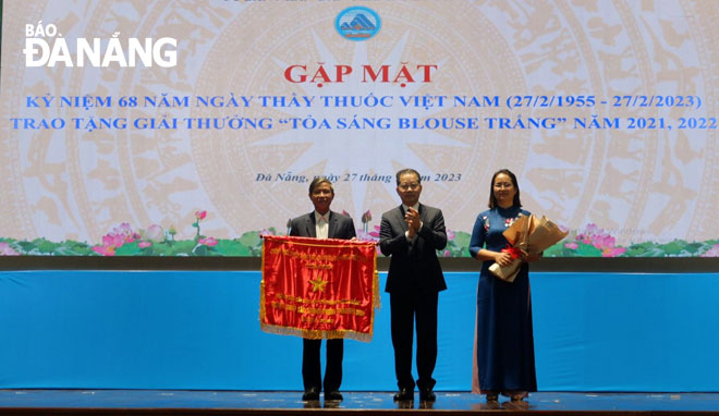 Da Nang Party Committee Secretary Nguyen Van Quang (middle) presents the naitonal government emulation flag to the 115 Da Nang Emergency Centre, February 27, 2022. Photo: PHAN CHUNG