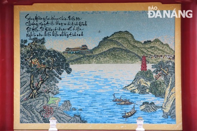 Bức tranh gốm với 4 câu thơ và những họa tiết nói về những địa danh nổi tiếng của xứ Huế. Ảnh: SƠN TRUNG