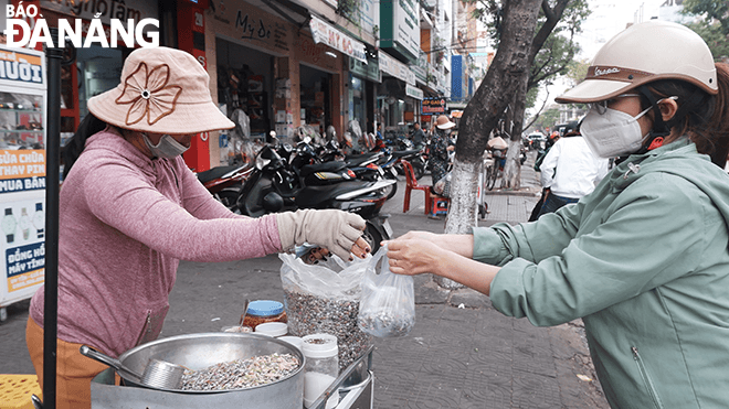 Mrs. Tran Thi Bich Thao (left) has been selling in tiny snail sales over the past 12 years.