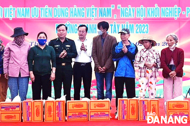 Đại tá Đỗ Văn Đông (thứ ba, bên trái sang), Bí thư Đảng ủy, Chính ủy Bộ đội Biên phòng thành phố trao quà cho người dân tại ngày hội Biên phòng toàn dân năm 2023. Ảnh: D.Q