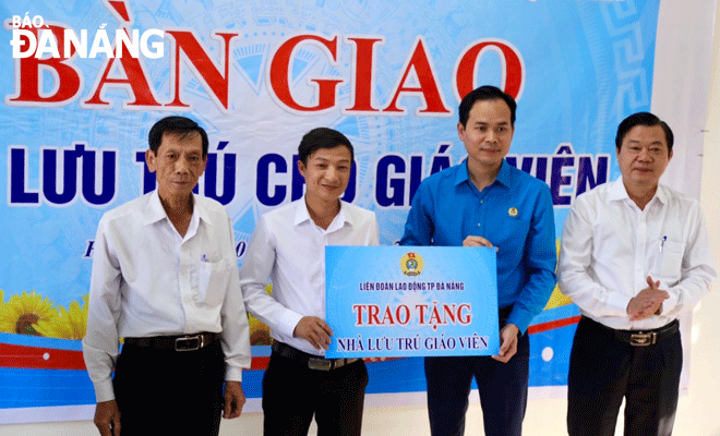 Chủ tịch Liên đoàn Lao động thành phố Nguyễn Duy Minh (thứ 2, bên phải sang) trao bảng bàn giao công trình cho đại diện lãnh đạo xã Hòa Bắc (huyện Hòa Vang). Ảnh: T.PHƯƠNG