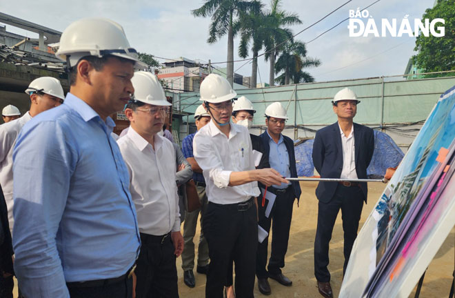 Ông Nguyễn Hữu Nhật (áo trắng, bên phải), Trưởng Ban Quản lý dự án Đầu tư xây dựng hạ tầng và phát triển đô thị báo cáo tiến độ dự án y tế trọng điểm tại Bệnh viện Đà Nẵng. Ảnh: PHAN CHUNG