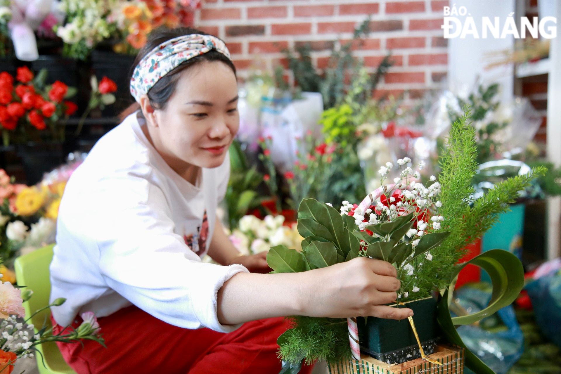 Các cửa hàng hoa tươi đang phải huy động nhân lực tại chỗ để cắm, bó hoa phục vụ nhu cầu tăng cao của khách hàng trong dịp lễ 8-3.