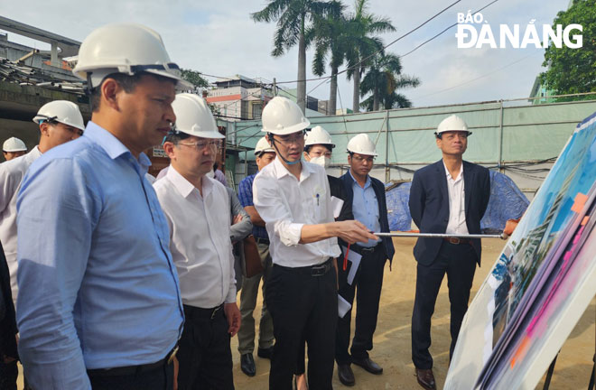 Mr. Nguyen Huu Nhat, the Director of the Da Nang Management Board for Urban Infrastructure Construction and Development Projects briefs the city leaders on the progress of key medical projects at the Da Nang General Hospital. Photo: PHAN CHUNG