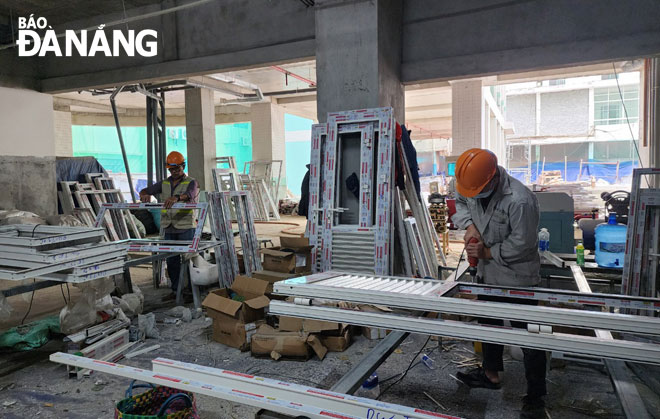 Workers are installing frames and doors at the Centre for Neurosurgery, Trauma and Plastic Surgery Center project under the Da Nang General Hospital. Photo: PHAN CHUNG