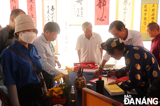 Hội Hán Nôm thành phố viết tặng thư pháp cho người tham gia lễ hội.
