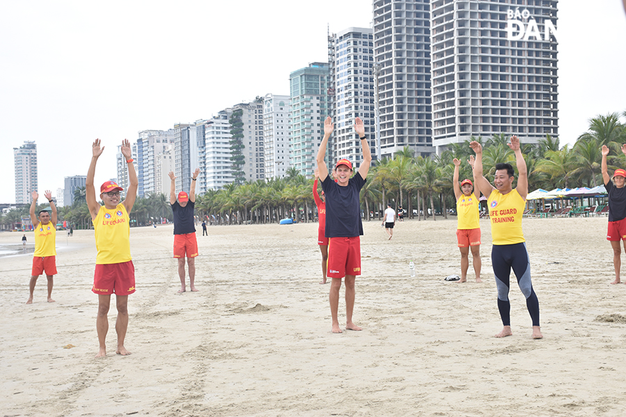 A volunteer from the Australian Rescue Association (middle) instructs signals for help to Da Nang's lifeguards. Photo: THU HA