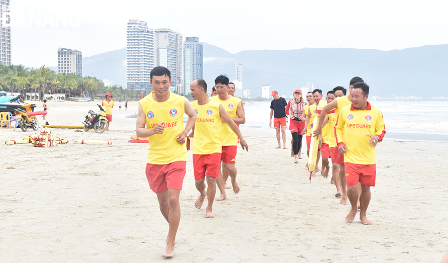 Volunteers test fitness and rescue skills at the beach such as the recognition of seawater flow, rescue signals, victim transporting, and identification, and simulated CPR first aid. Photo: THU HA