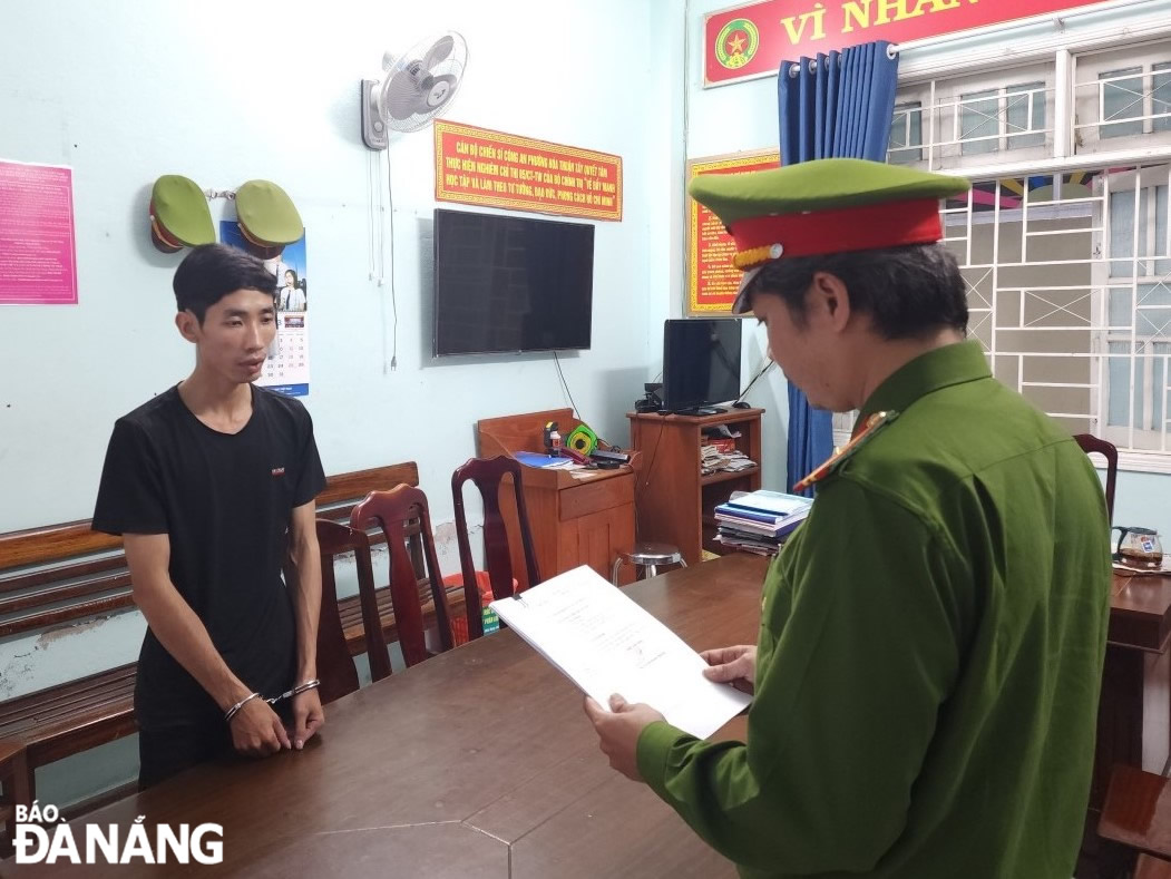Cơ quan Cảnh sát điều tra, Công an quận Hải Châu thực hiện lệnh bắt tạm giam đối tượng Nguyễn Ngọc Hiếu (bên trái). Ảnh: L.H