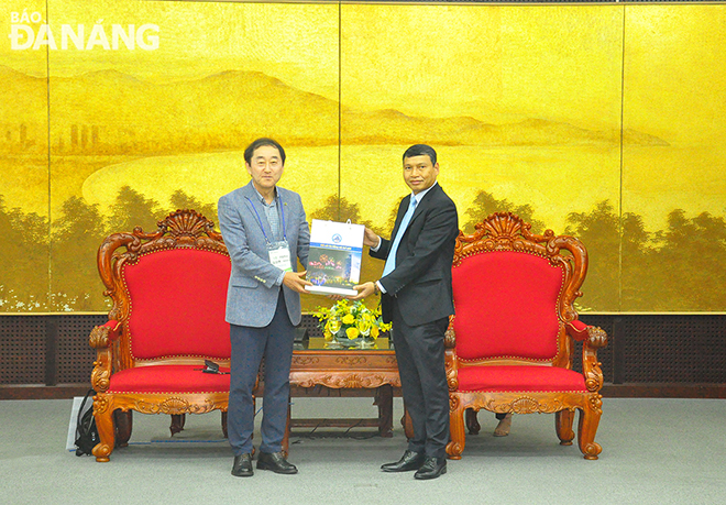 Phó Chủ tịch Thường trực UBND thành phố Hồ Kỳ Minh (bìa phải) tặng quà lưu niệm của thành phố cho ông Sanghuyn Kim, Chủ tịch Hiệp hội doanh nghiệp nhỏ và vừa khu vực Daejeon - Sejong - Chungnam (Hàn Quốc)  .Ảnh: THÀNH LÂN - VĂN HOÀNG