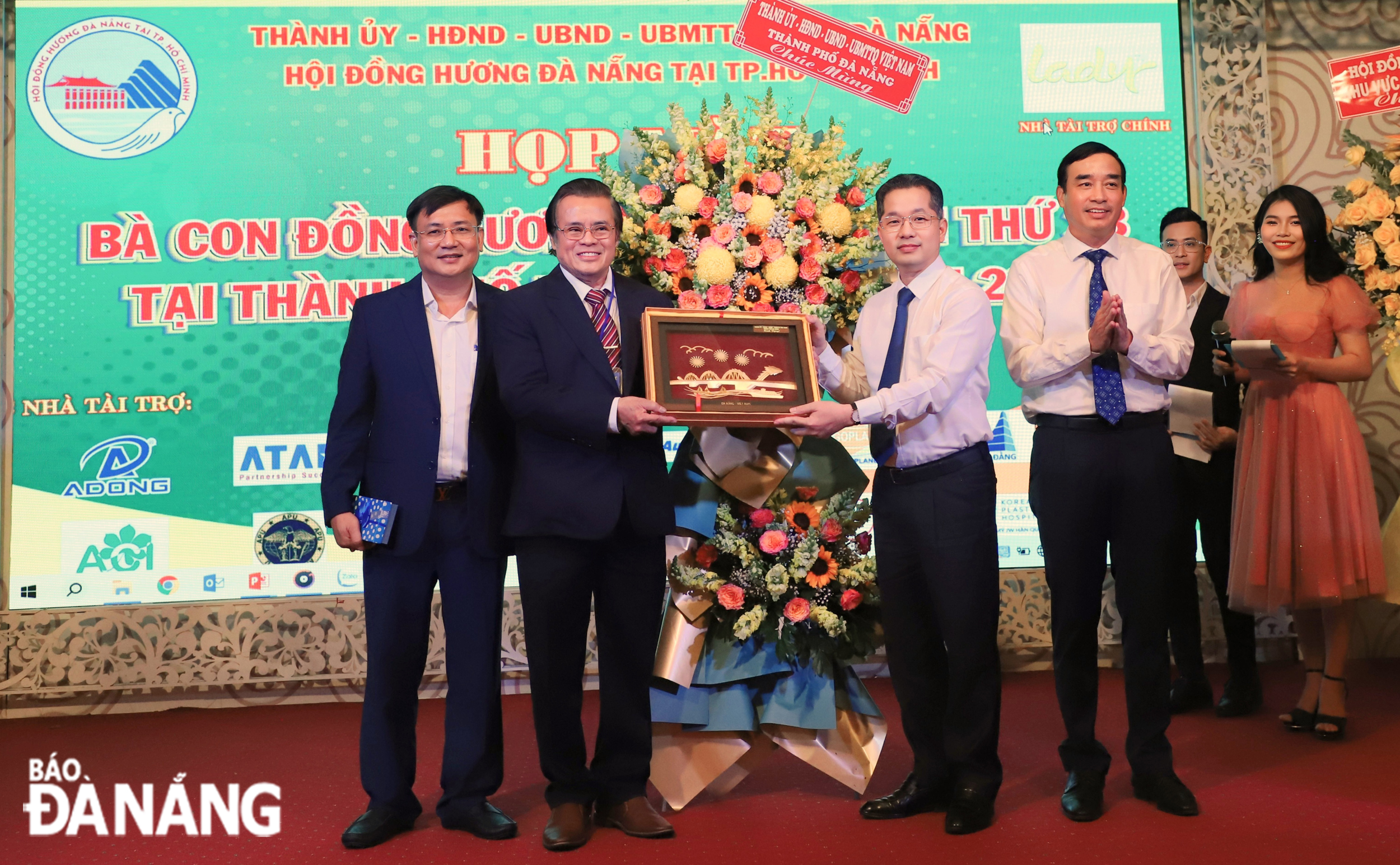 Da Nang Party Committee Secretary Nguyen Van Quang (2nd, right) and municipal People's Committee Chairman Le Trung Chinh (1st, right) present flowers to congratulate the Association of Da Nang Compatriots in HCMC. Photo: NGOC PHU