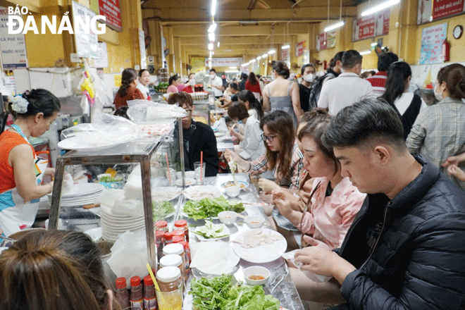 Nhiều chợ ở thành phố được du khách lựa chọn làm điểm đến và ẩm thực địa phương rất được du khách yêu thích. Trong ảnh: Du khách chọn món bún nắm, thịt heo luộc tại  chợ Hàn. Ảnh: QUỲNH TRANG